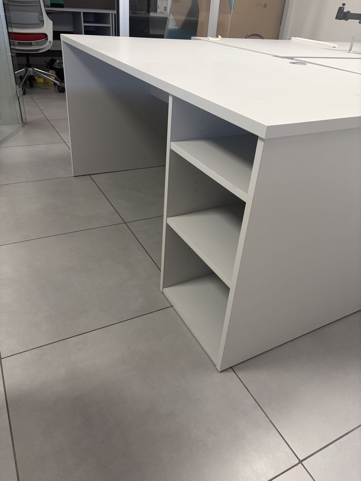 Bureau professionnel finition gris, avec rangement intégré sur le côté.
